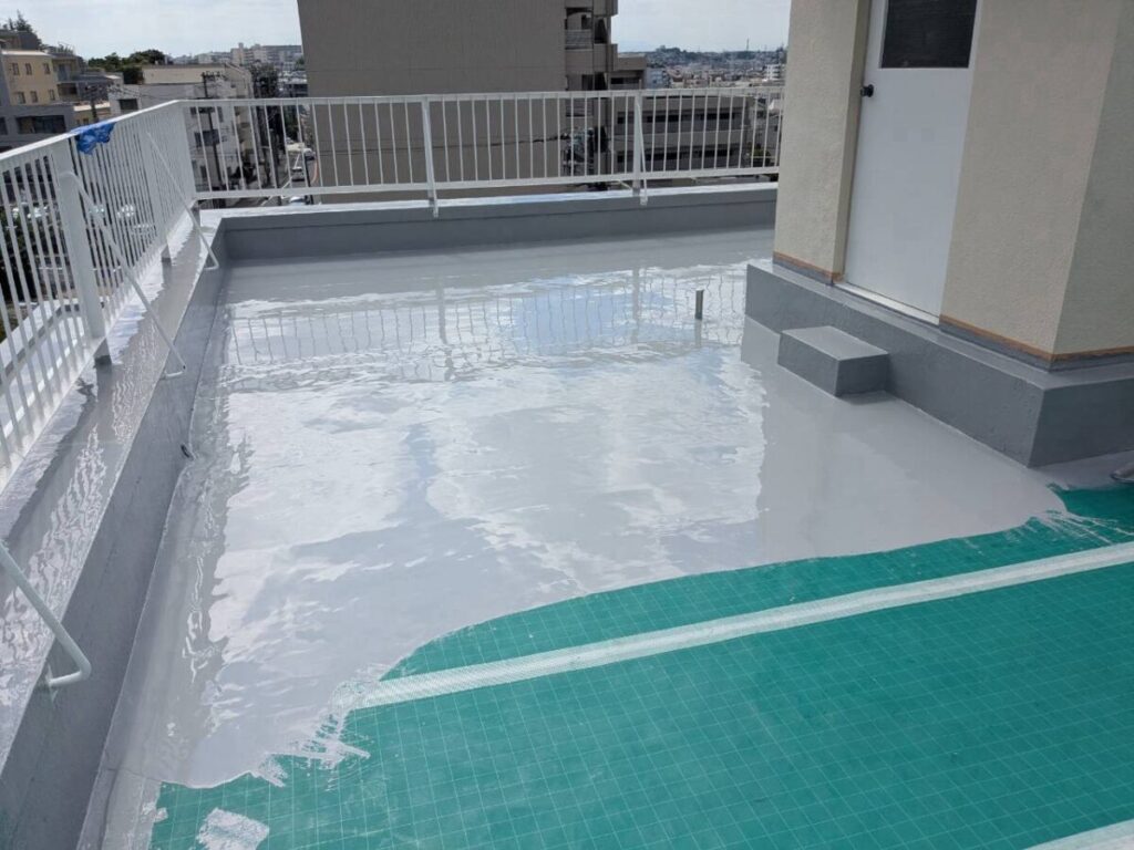 通気シートの上へウレタン1層目を塗り広げている、平場の施工途中の様子です。