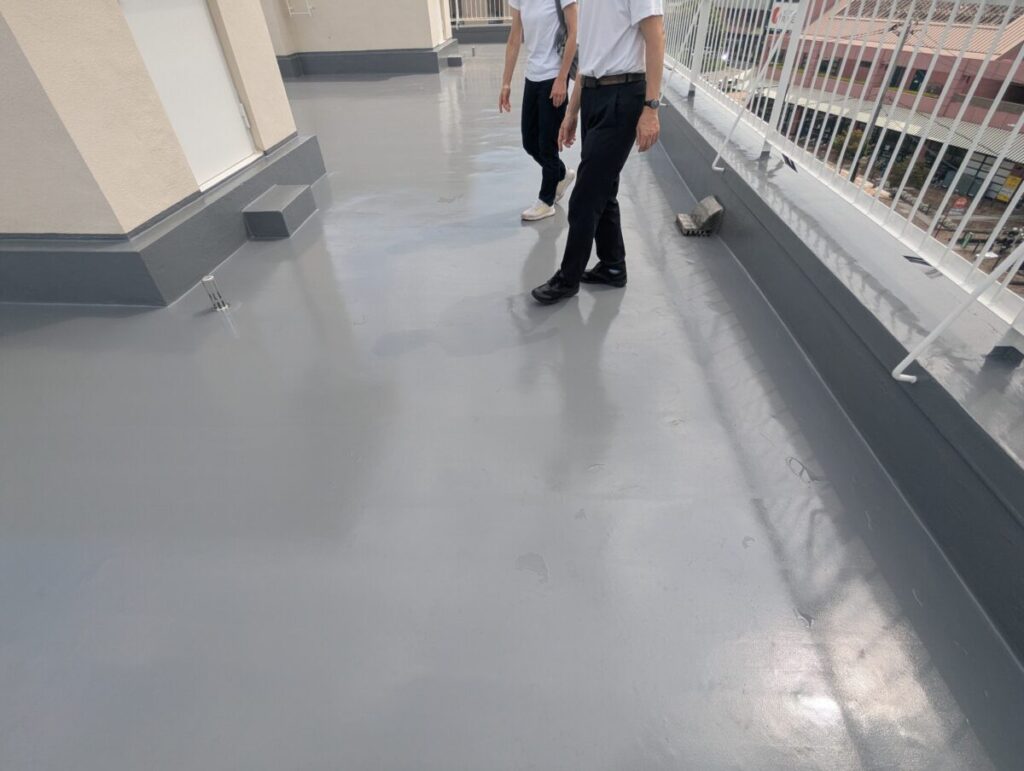 施主様と担当者が完成した屋上を一緒に確認している、完工検査の様子です。